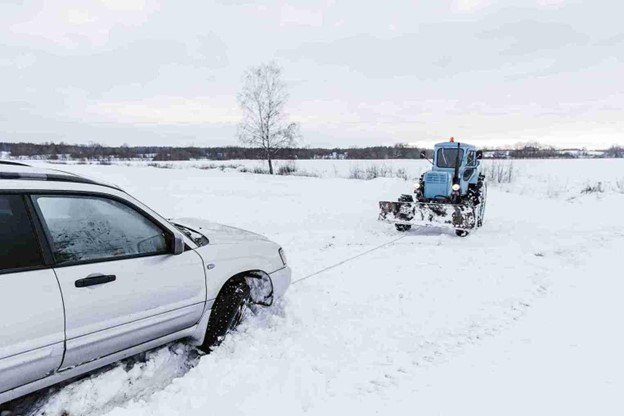 A car getting winched out by Cuyahoga Towing after a car stuck in the snow