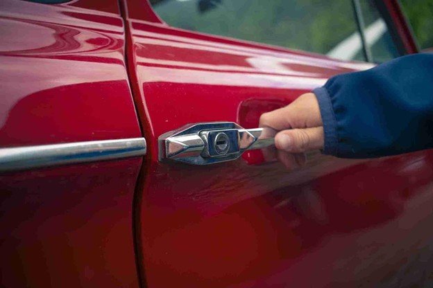 Technician unlocking a car door using professional lockout tools during a roadside vehicle lockout service