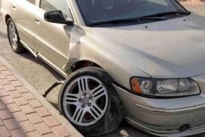 Car with a damaged front wheel pulled over along the roadside after a breakdown